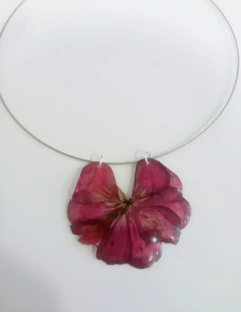Rigid necklace with a pink flower set in resin