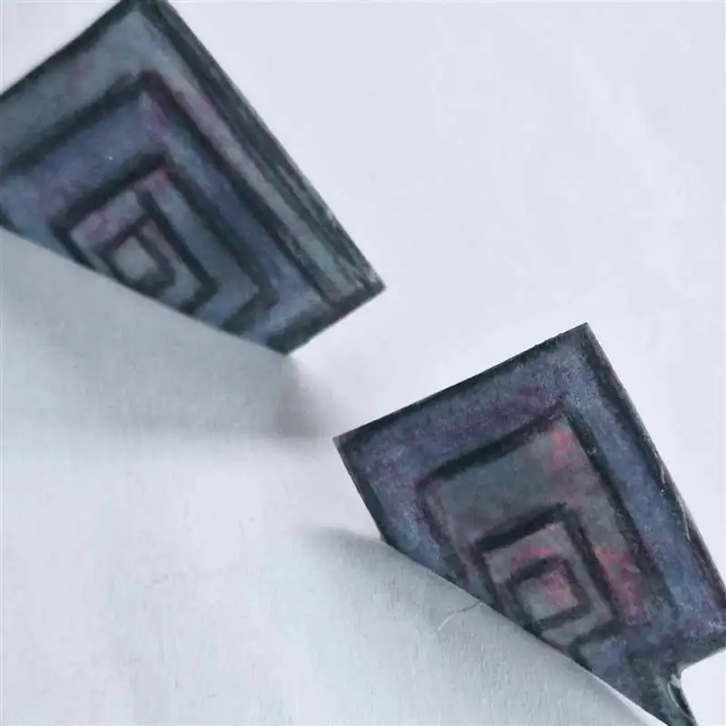 Pendientes artesanales de resina en tonos violeta y azul con dibujo geométrico, color que recuerda a la amatista