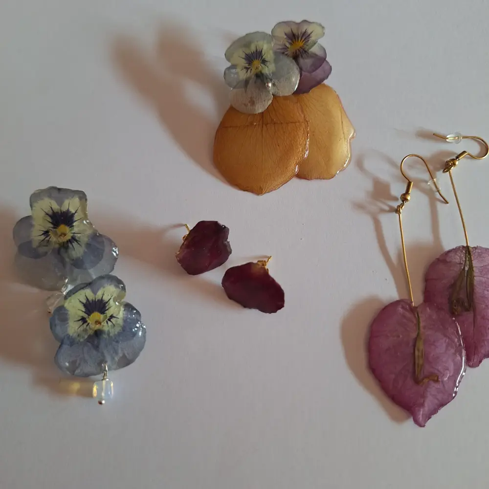 Pendientes de resina con pensamientos y pétalos hechos en un taller en Barcelona