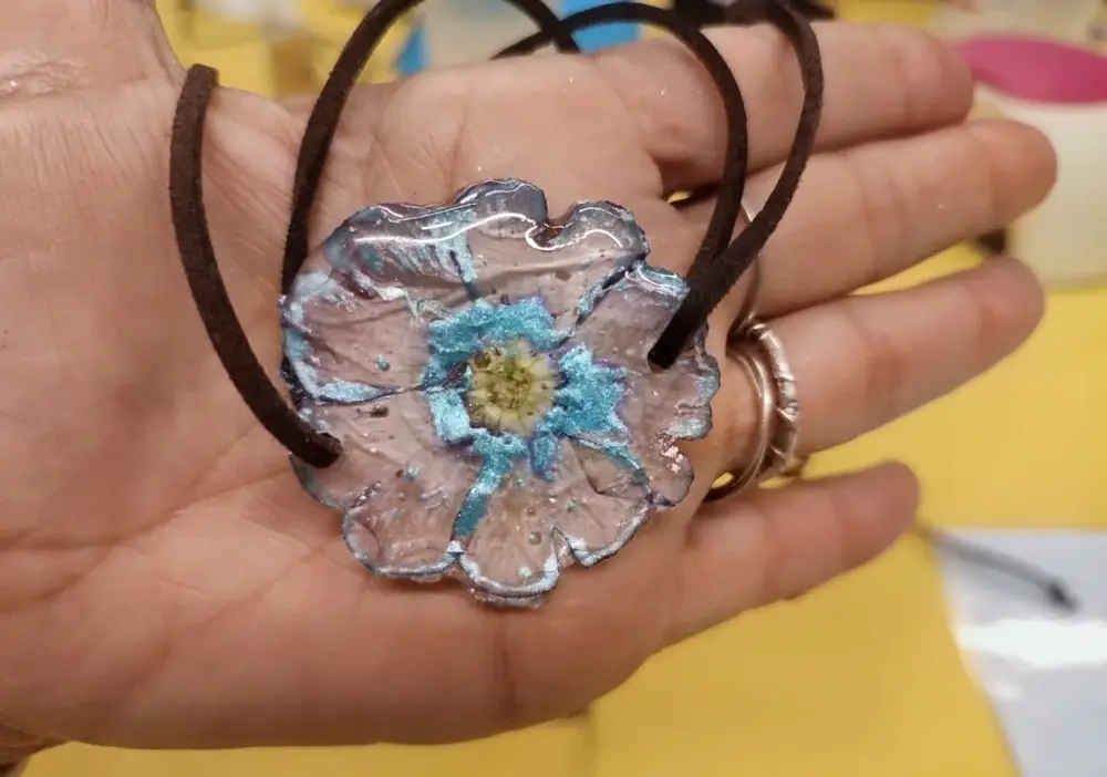 Colgante de resina con flor azul creado en un taller de joyería en Barcelona